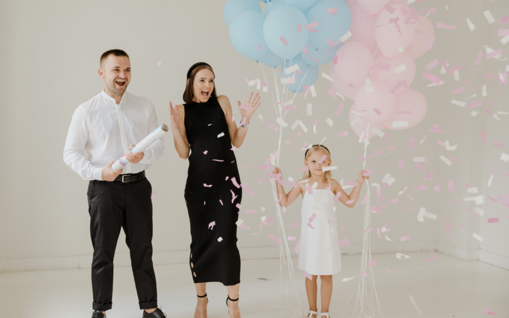 gender reveal with family and pink and blue balloons
