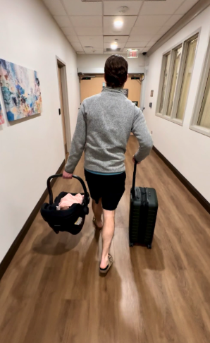 dad leaving the hospital with new baby