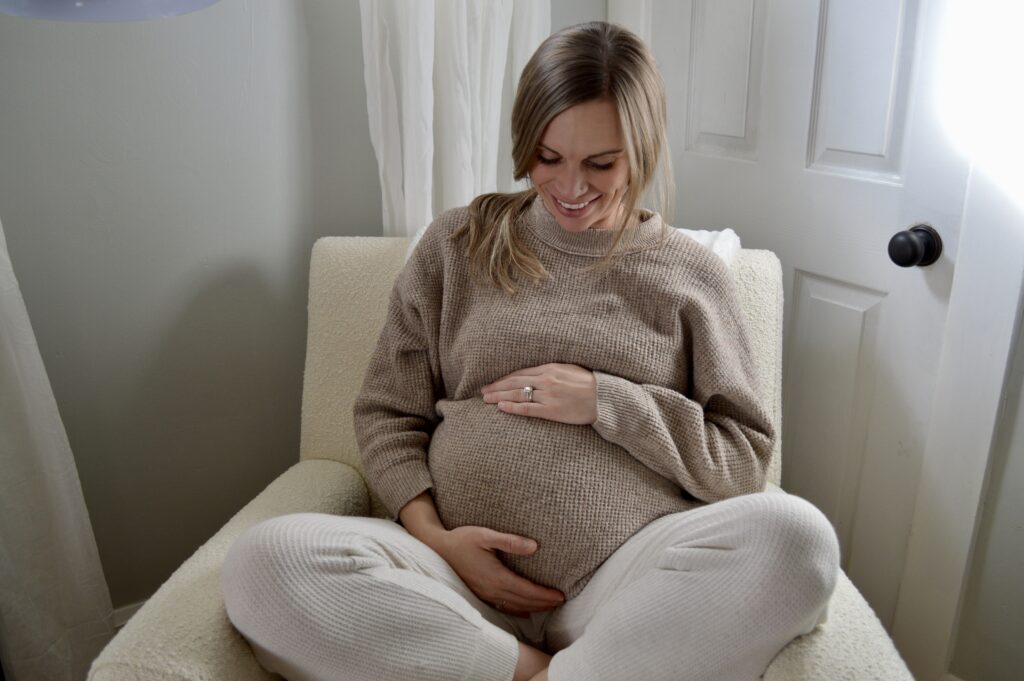 pregnant woman in rocking chair in nursery